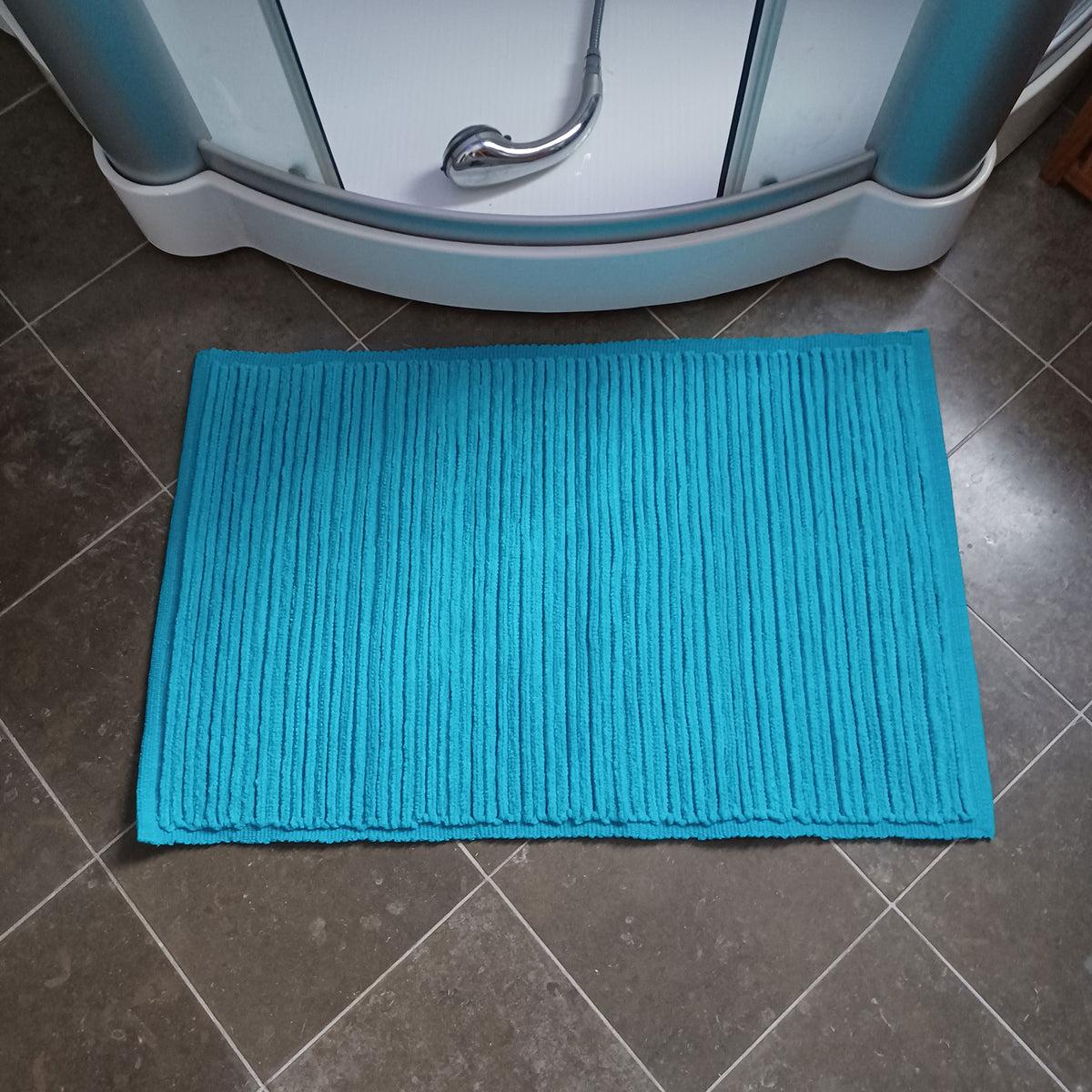Ribb turkos 60 × 90 cm från Etol, ribbad bomullsmatta på mörkt klinkergolv i badrumsmiljö | Molectric