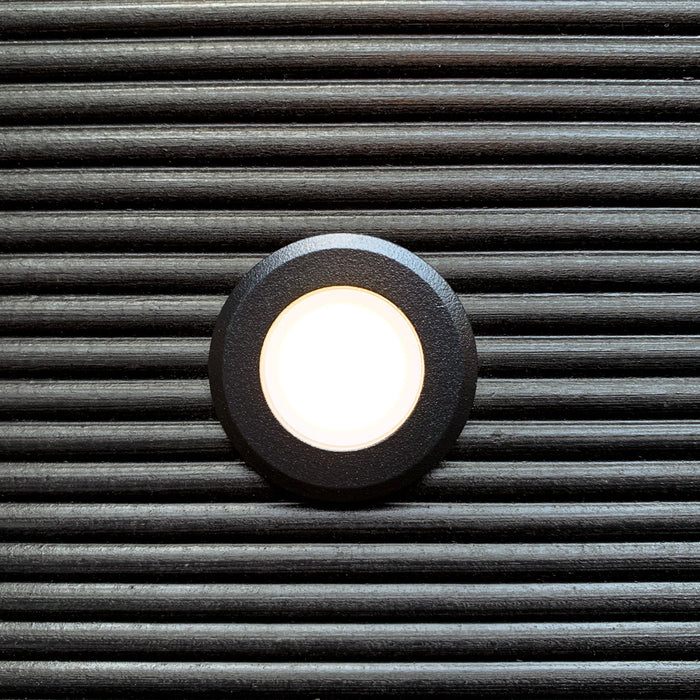 Orion Svart decklight med varmvit belysning infälld i mörkt trädäck | Molectric