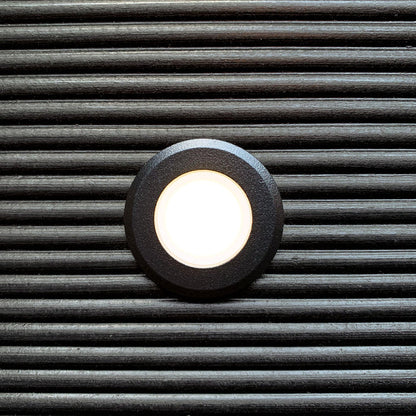 Orion Svart decklight med varmvit belysning infälld i mörkt trädäck | Molectric