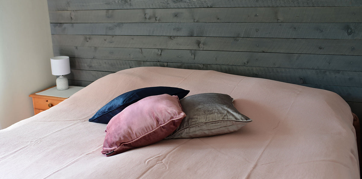 Överkast Stripes Dusty Rose på säng med kuddar i sammet | Molectric